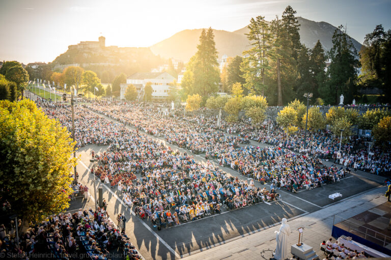 ein Platz voller betender Menschen in Lourdes